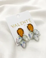 Aros colgantes con forma de racimo, con un cristal color ámbar en la parte superior y varios cristales iridiscentes en forma de lágrima en la parte inferior.