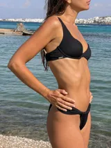 Parte inferior de bikini tipo colaless, color negro, con detalle de frunces ajustables en los laterales.