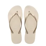 Sandalias de dedo Havaianas modelo Slim, color beige con tiras finas doradas metalizadas.