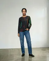 Remera de manga larga con cuello redondo, confeccionada en tejido elástico y liviano. Presenta un estampado abstracto inspirado en texturas orgánicas en tonos oscuros, verdes y rojizos.