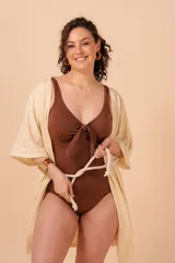 Túnica color crema con calados tipo broderie, escote en V y mangas cortas amplias. Incluye cordón de algodón para ajustar en la cintura.