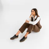 Zapato mocasín de cuero vacuno color negro, con cordones y punta redonda. Tiene taco de madera foliado en cuero de 2,5 cm y entre suela de goma de 1 cm.