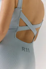 Mono corto tejido de color celeste, sin costuras y con espalda descubierta con tiras cruzadas.