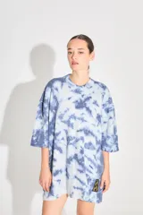 Sweater de punto tipo remerón oversize con diseño batik artesanal en tonos azul y blanco. Presenta silueta amplia, manga caída y etiqueta tejida con monograma en el frente.