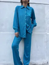 Camisa turquesa de manga larga con botones.