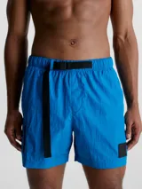 Bañador corto de largo medio Calvin Klein CK Nylon, color azul eléctrico, con cintura elástica, cordón de ajuste y cinturón de cinta con hebilla y logo. Incluye bolsillos laterales, bolsillo trasero con cremallera y forro de malla.