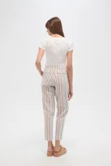 Pantalón tipo babucha de corte recto y holgado, con estampado de rayas verticales en tonos beige, blanco y verde agua. Cuenta con cintura elástica con cordón ajustable y borlas decorativas en los extremos.