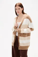 Saco de punto con diseño de rayas horizontales en negro, gris y blanco. Presenta cuello en V, cierre frontal con botones y bolsillos laterales.