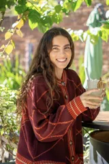 Saco tejido de punto con diseño geométrico de rombos en color azul y blanco. Presenta cuello redondo, cierre frontal con botones, mangas largas abullonadas y terminaciones acanaladas en puños y ruedo.