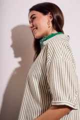Camisa oversize a rayas verticales color verde y blanco, con mangas cortas y botones nacarados.