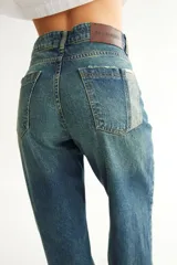 Jean negro de corte recto con recortes laterales, roturas en bolsillos, pespuntes a contratono y zigzag característico de la marca BG.