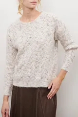 Buzo de punto con cuello redondo, manga larga y textura jaspeada en tonos beige y crema.