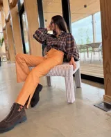 Camisa de corte oversize con estampado a cuadros en tonos verde y azul. Presenta mangas abullonadas con puños elásticos y cierre frontal con botones.