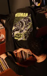 Remera de algodón premium con calce oversize, cuello redondo y mangas cortas. Presenta un estampado gráfico frontal con temática de Daft Punk en tonos verdes y negros.