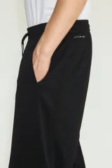 Jogger deportivo de corte relajado y piernas rectas, color negro, confeccionado en tejido funcional con tecnología DryMove. Cuenta con cintura elástica revestida con cordón de ajuste y bolsillos laterales insertados.