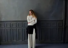 Blusa de poliéster color blanco con cuello redondo drapeado y mangas largas.