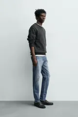 Pantalón de jean corte slim fit, color gris con efecto lavado. Presenta diseño de cinco bolsillos, cierre frontal con cremallera y botón, y tejido elástico.