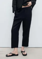 Pantalon de lino color negro, de corte recto y tiro alto, con cintura elástica y cordón ajustable.