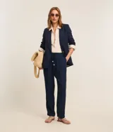 Pantalón fluido Marfinno modelo pijama, color blanco, confeccionado en viscolino. Cuenta con cintura elástica en la espalda, lazo de ajuste, pliegues frontales y bolsillos laterales.