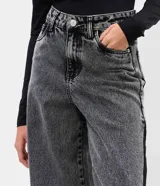 Pantalón wide leg de jean azul con diseño de recorte lateral en tono contrastante. Presenta cintura mediana con trabillas, cierre tradicional y bolsillos funcionales.