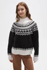 Sweater de tejido jacquard con diseño nórdico, cuello alto y corte holgado. Presenta una combinación de colores blanco y negro con detalles geométricos en el canesú y los puños.