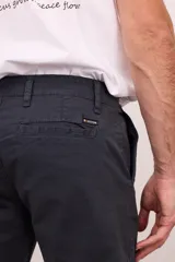 Bermuda de vestir de gabardina color azul marino, de corte regular, con bolsillos laterales y traseros, y cierre frontal con botón y cremallera.