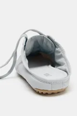 Zapato deportivo destalonado de tejido gris claro, con cordones y suela engomada con relieve de color caramelo.