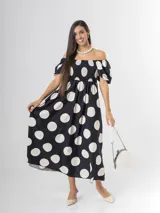 Vestido largo de lunares con escote bote y hombros descubiertos, mangas cortas abullonadas, cuerpo con nido de abeja y falda amplia.