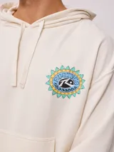Canguro color crema con efecto lavado, confeccionado en mezcla de algodón y poliéster. Presenta un estampado circular en el pecho con motivos de sol y el logo de Rusty.