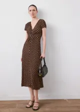 Vestido midi marrón con estampado de lunares claros, escote en V, manga corta y detalle de nudo en el pecho.