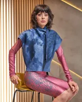 Chaleco de lana merino afieltrada, con grandes hombros y entallado a la cintura. El cuello es un lazo que se puede anudar de infinitas maneras. El color "azules" es único, renace del teñido artesanal con la técnica Tie Dye permitiendo descubrir diferentes matices y acuarelas únicas.