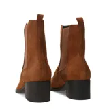 Botas de caña baja estilo chelsea, confeccionadas en gamuza color marrón camel. Presentan paneles elásticos laterales al tono, taco cuadrado bajo y suela de goma.