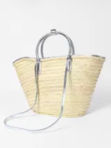 Bolso canasto Jacquemus Le Panier Soli tejido en fibra vegetal con detalles en cuero metalizado plateado, dos asas cortas de mano y bolsillo frontal con logotipo en letras doradas.