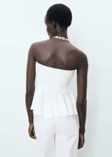 Top de estilo palabra de honor con diseño peplum en la cintura. Presenta un corte ajustado en el torso y un bajo con vuelo, confeccionado en un tejido estructurado.