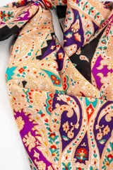 Bandana cuadrada con estampado paisley en tonos violeta, fucsia, negro y beige.
