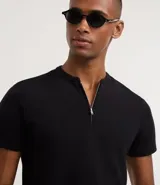 Remera masculina negra de algodón peruano, corte slim, con cuello padre y abertura frontal con cremallera metálica. Tiene mangas cortas.