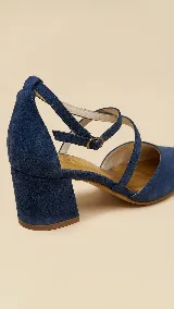 Zapato de tacón ancho de 5 cm, confeccionado en tela de tapicería resistente color negro. Presenta un diseño con escote en V y tiras cruzadas en diagonal con cierre de hebilla en el tobillo. Cuenta con forro y plantilla de cuero.