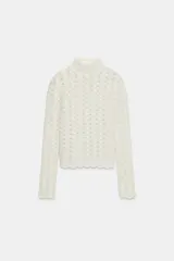 Jersey de punto con cuello subido y manga larga, confeccionado con un diseño de tejido combinado que presenta una textura calada y delicada.