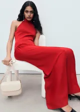 Vestido largo de punto fino color rojo, con diseño combinado, cuello halter y espalda descubierta. Presenta un ajuste al cuerpo en la parte superior y una falda evasé con caída fluida.