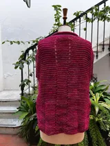 Chaleco tejido a mano en dos agujas con hilado 100% baby alpaca teñido artesanalmente, color magenta matizado. Diseño ligeramente oversize, de hombros anchos y cuello tipo bote, con puntos calados en frente y espalda y tajos a los lados en el bajo.