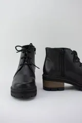 Borcego color suela de cuero con plataforma tractorada, cordones y cierre lateral.