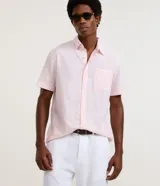 Camisa de manga corta confeccionada en mezcla de lino y algodón, con cuello inglés, cierre frontal de botones y bolsillo en el pecho. Presenta un corte comfort holgado y diseño liso.