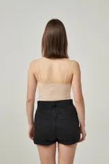 Musculosa de bretel fino color crudo, corte ajustado al cuerpo y escote redondo.