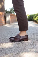 Zapato de cuero marrón con puntera fina y pequeño taco cuadrado.