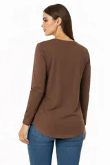 Remera de manga larga color beige, con cuello redondo y estampado frontal con efecto foil metalizado y texto.