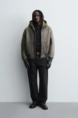 Cazadora relaxed fit de Zara confeccionada en tejido efecto piel con acabado lavado, interior de borreguillo a contraste, capucha, bolsillos de vivo en la cadera, acabados en rib y cierre frontal de cremallera.