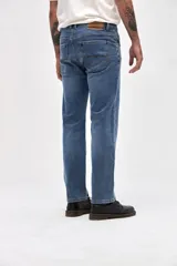 Jean de corte slim, ajustado desde la cadera hasta los tobillos, en color azul medio con acabado clásico.