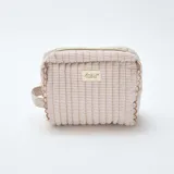 Neceser de formato rectangular con diseño acolchado y estampado de rayas finas en tonos beige y blanco. Cuenta con cierre superior, asa lateral y etiqueta decorativa con la inscripción Beauty Club Collection.