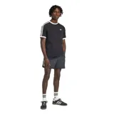 Remera Adidas negra de manga corta con cuello redondo, las clásicas tres franjas blancas en las mangas y el logo de Adidas en el pecho.