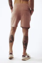 Shorts de algodón color rosa viejo, estilo jogging, con cordón ajustable en la cintura y corte por encima de la rodilla.